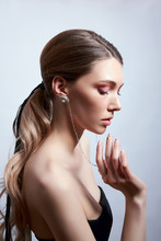 Beauty Portrait Of A Woman With Long Hair, Earrings In Her Ears And Expensive Jewelry On Her Hands