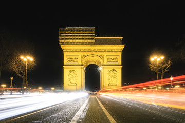 Wall Mural - Beautiful cityscape urban street view of the Arc de Triomphe in Paris, France, on a spring evening after sunset at night, seen from the Champs-Elysees with traffic