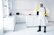 © deagreez - Full size photo of confident successful guy cleaner show in gloves coverall thumb up symbol approve stop spread ncov epidemic treatment wear boots yellow latex gloves goggles in house kitchen indoors