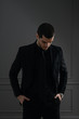 © arthurhidden - Young handsome businessman in black shirt and black suit. Confident young businessman posing on gray background