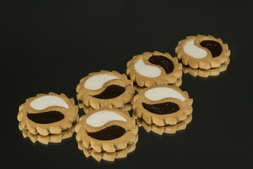 Cookies with white and dark chocolate on a black background