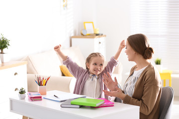 Sticker - Mother and daughter doing homework together at table indoors