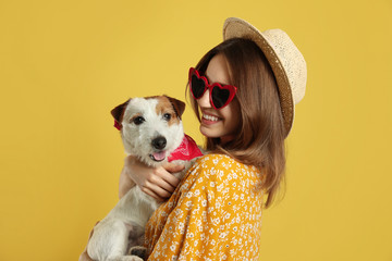 Wall Mural - Young woman with her cute Jack Russell Terrier on yellow background. Lovely pet