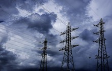Low Angle View Of Silhouette Electricity Pylons Against Blue Cloudy Sky