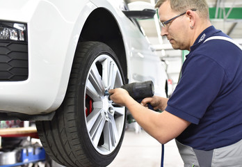 car mechanic changes the tires of the vehicle in the workshop