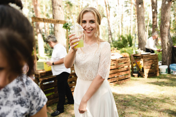 the bride and groom enjoy drinks in the circle of guests in nature,the bride and groom enjoy a drink with guests in the garden,wedding day of a couple in love