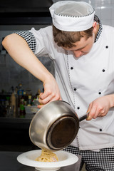 Wall Mural - Guy cook preparing delicacies in the restaurant kitchen.