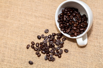 Cup of coffee with coffee beans on old background