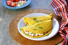 Chilla, Tortillas Or Pancakes Made From Chickpea Flour Stuffed With Cheese Panir And Tomato On A White Plate On A Gray Concrete Background. Indian Food, Street Food. Vegetarian Recipes.