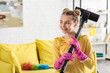 © LIGHTFIELD STUDIOS - Child with vacuum cleaner smiling and looking away in living room