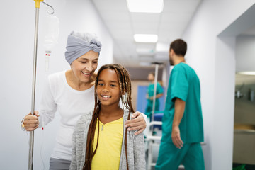 Wall Mural - Sick woman with cancer hugging her young grandchild in hospital. Family support concept.