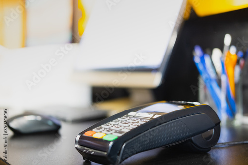 Payment terminal on a table, close-up view. POS terminal at cashier desk of a retail store, local business concept