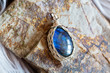Beautiful mineral labradorite stone pendant on rocky background