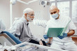 © prostooleh - Handsome old man talking to the dendist. Two man in the dentist's office