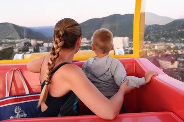 Wall Mural - Mother and son enjoying aerial cityscape view from the Ferris wheel