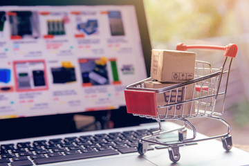 Shopping online. cardboard box with a shopping cart logo in a trolley on laptop keyboard. Shopping service on The online web. offers home delivery
