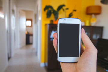 Close up view of man's hand holding smartphone with blank black screen