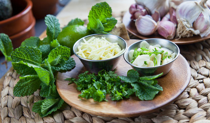 Wall Mural - Sliced garlic and ginger with healthy herbs -  coriander, mint and lime -  healthy diet ingredients with Asian inspiration.