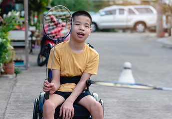 Wall Mural - Asian special child on wheelchair is playing badminton to strengthen muscles in the house, Lifestyle of disabled child,Life in the education age of children, Happy disability kid stay at home concept.