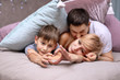 © Arina Makarenko - Happy family on a bed with soft pillows at home. Hands represent the heart