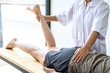 © Thitiphat - Doctor or Physiotherapist working examining treating injured leg of athlete male patient, Doing the Rehabilitation therapy pain in clinic