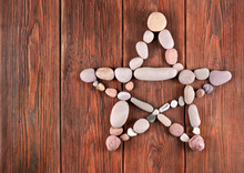 Pentagram Made Of Stones On A Wooden Background. Top View. Text Space.