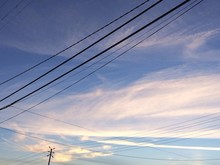 Power Lines Against Cloudy Sky