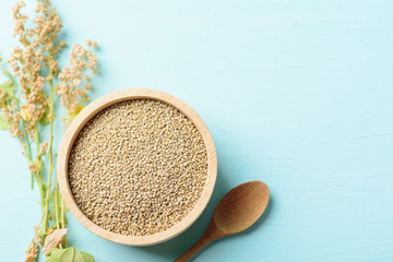 Organic brown quinoa seed in a wooden bowl on pastel color background, Healthy food