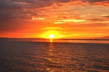 Idyllic Shot Of Manila Bay Against Orange Sunset Sky