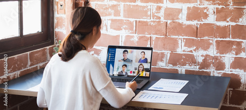 Fotomural Young Asian businesswoman work at home and virtual video conference meeting with