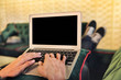 © ImageHit - Man using a laptop on a couch