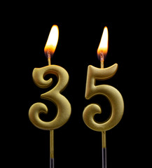 Burning golden birthday candles on black background, number 35