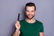 © deagreez - Portrait of positive cheerful guy demonstrate hairbrush enjoy anti dander haircare procedure wear good look outfit isolated over gray color background