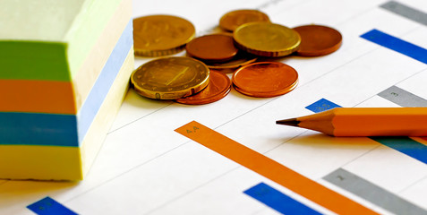 Top view of business chart on white table with pencil, stickers and money