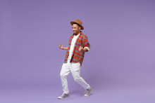 Happy Young African American Guy In Casual Colorful Shirt Hat Posing Isolated On Violet Background Studio Portrait. People Emotions Lifestyle Concept. Mock Up Copy Space. Clenching Fists Like Winner.