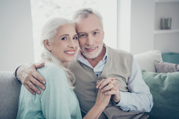 Poster - Photo of pretty aged pair leaning heads holding hands posing family portrait sitting cozy sofa indoors