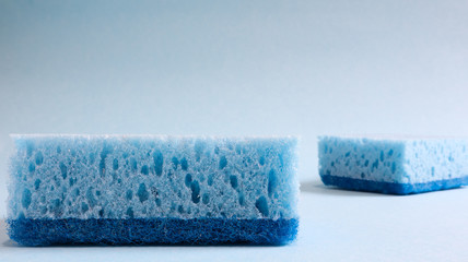 Wall Mural - Two blue sponges used for washing and erasing dirt used by housewives in everyday life. They are made of porous material such as foam. Detergent retention, which allows you to spend it economically