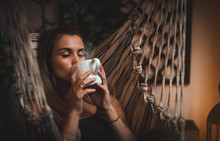 Dreamy Woman Sitting On Balcony At The Evening And Drinking Coffee