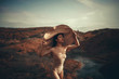 © Stanislav - Woman in bodysuit and hat stands on the background of canyon.