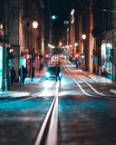 Fototapeta Uliczki - Person Crossing The Street At Night