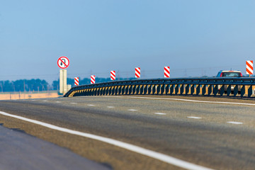 A metal separator of directions on an asphalt road between cities. Road safety