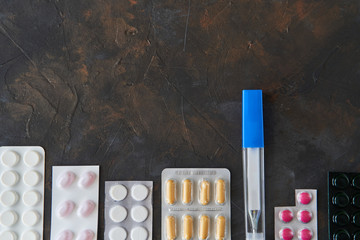 Wall Mural - Pills capsules medicine health on dark background top view, medical pharmacy concept. Different pills on dark background with copy space.