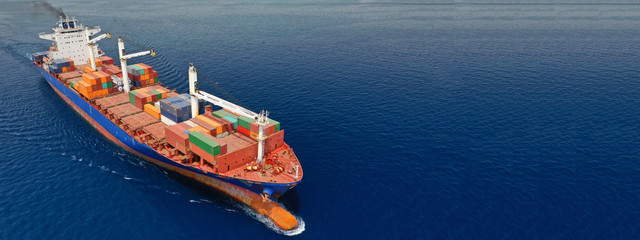 Aerial drone panoramic ultra wide photo of industrial container tanker ship cruising in open ocean deep blue sea	
