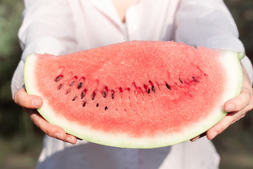 Woman holding piece of juicy sweet watermelon