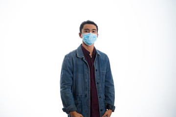 An Asian young man isolated on white background with casual entire and wearing a face mask. Hand gesture stop, sick, respect. during corona virus 