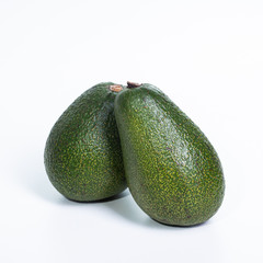 a pair of fresh avocados isolated on a white background.