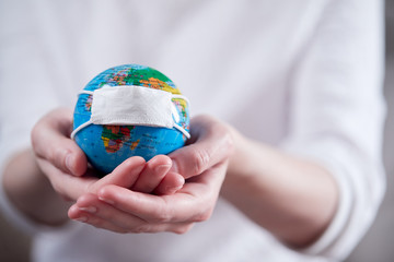 woman holding globe with protective mask