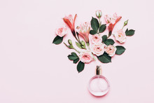 Bottle Of Perfume And Flower Arrangement Of Rosebuds On Pink Background