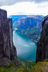 Wonderful mountain landscape of Lysefjorden with clouds reflected in blue water. View from Kjerag plateau, where not far at an altitude of 984 meters stuck between two rocks of Kjeragbolten. Norway.