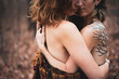 © Cavan Images - artistic faceless portrait of female gay couple hugging in woods